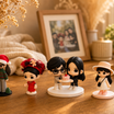 A hand holds a printed family photo beside the matching custom WishFigure chibi family figurines