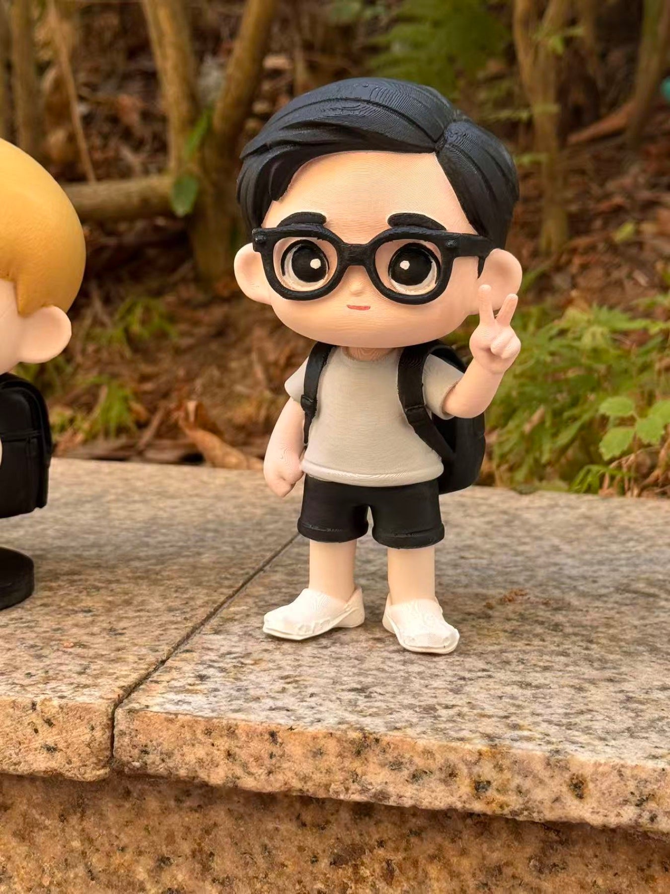 A custom chibi figurine of a boy displayed outdoors as a personalized keepsake